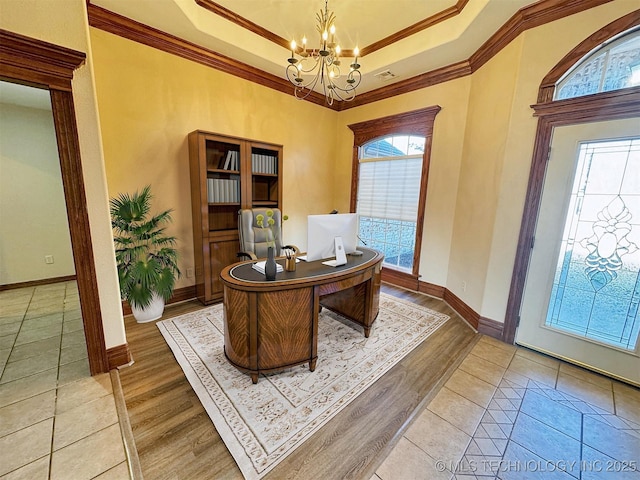 office space featuring a chandelier, a raised ceiling, baseboards, ornamental molding, and wood finished floors