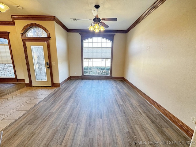 foyer entrance featuring crown molding, a ceiling fan, wood finished floors, and baseboards