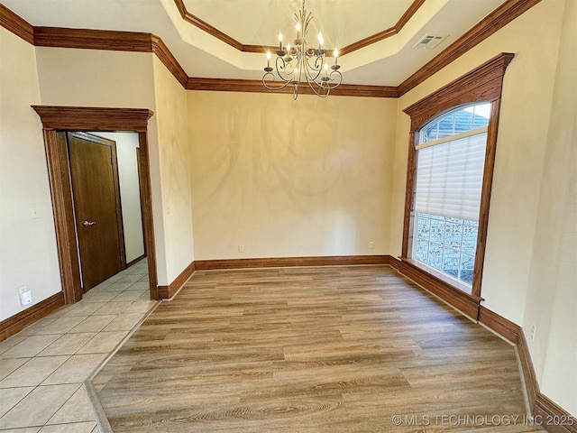 unfurnished dining area with a chandelier, a raised ceiling, ornamental molding, light wood-type flooring, and baseboards