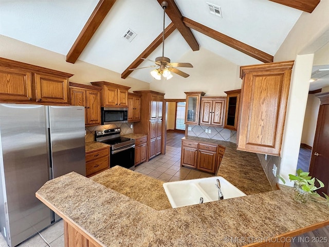 kitchen featuring appliances with stainless steel finishes, a sink, light tile patterned flooring, high vaulted ceiling, and a ceiling fan
