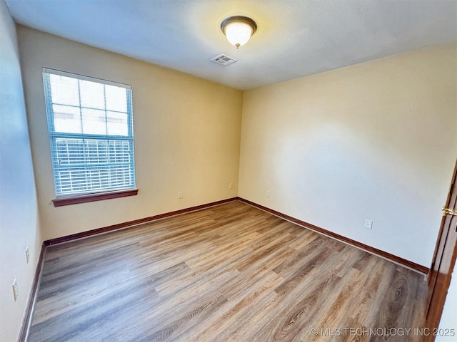 empty room with light wood finished floors and baseboards