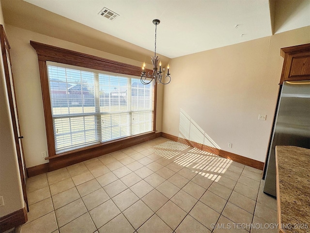 unfurnished dining area featuring light tile patterned flooring, a chandelier, and baseboards