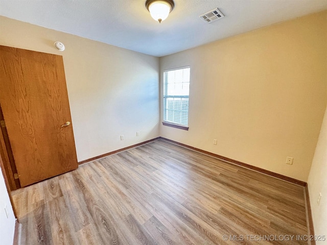 spare room with wood finished floors and baseboards