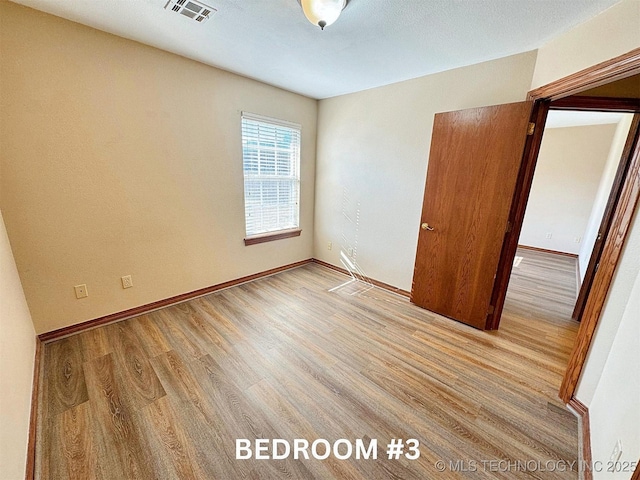 unfurnished bedroom with light wood finished floors and baseboards