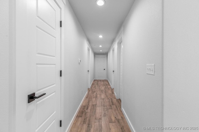 hall with baseboards, recessed lighting, and wood finished floors