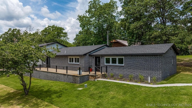 view of front of property with a deck, a front yard, and roof with shingles