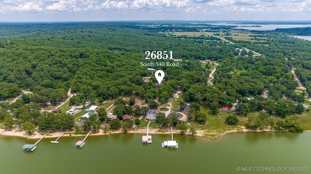 drone / aerial view featuring a water view and a wooded view