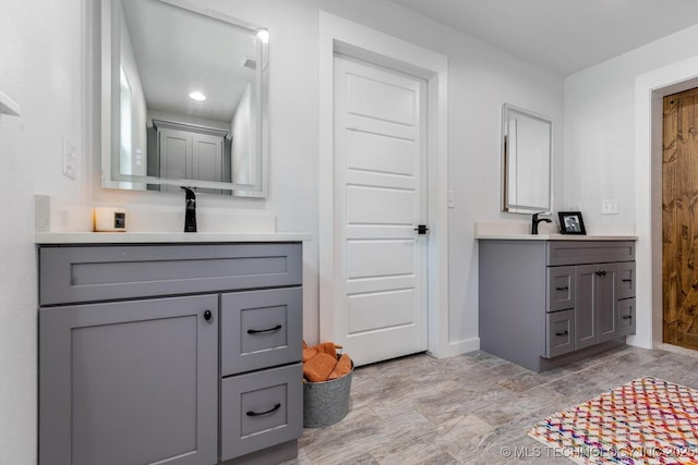 full bathroom featuring a sink, baseboards, visible vents, and two vanities