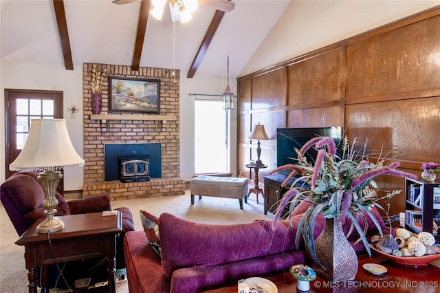 living room featuring a wood stove, ceiling fan, vaulted ceiling with beams, and carpet