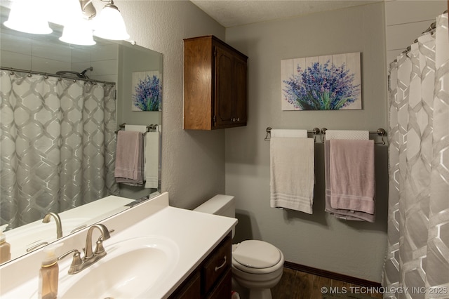 full bathroom with a textured wall, vanity, toilet, wood finished floors, and a shower with curtain