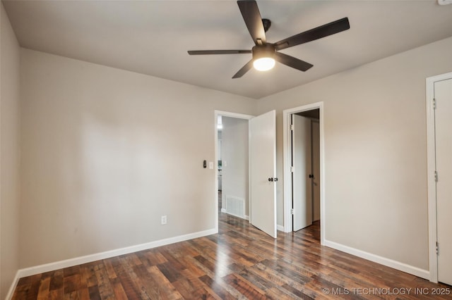 unfurnished bedroom with baseboards, dark wood finished floors, and visible vents