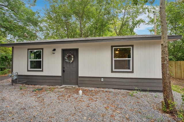 ranch-style home featuring fence