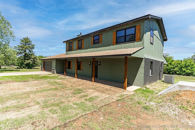 view of front of property with roof with shingles, brick siding, central AC, concrete driveway, and an attached garage