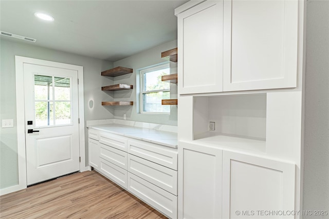 kitchen featuring plenty of natural light, visible vents, open shelves, light countertops, and white cabinetry