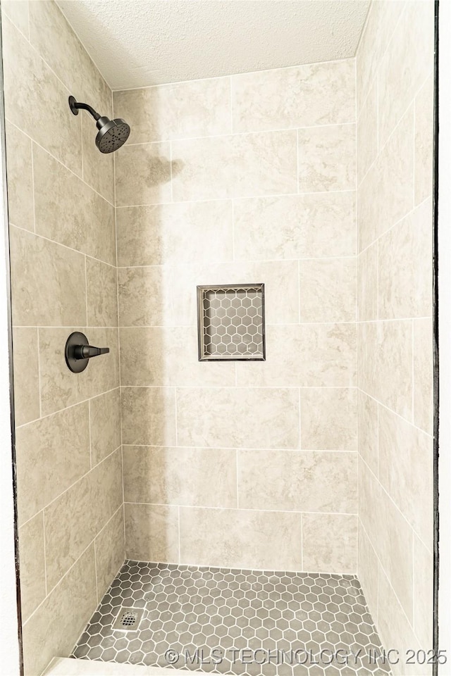 full bath featuring a shower stall and a textured ceiling