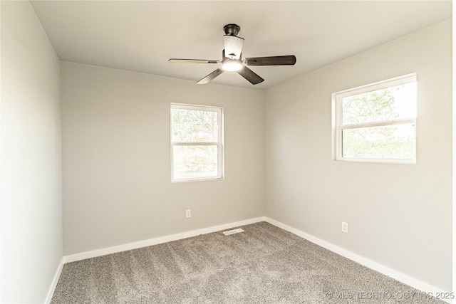 carpeted empty room with visible vents, baseboards, and ceiling fan