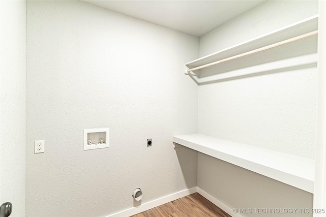 clothes washing area featuring laundry area, hookup for a washing machine, electric dryer hookup, baseboards, and light wood-type flooring