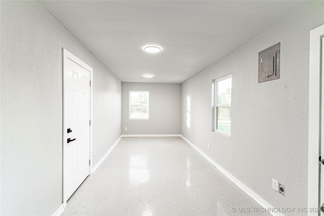 interior space with baseboards and a textured wall