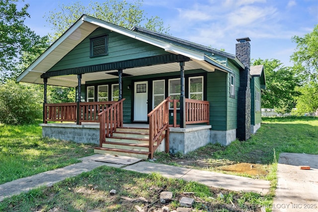 bungalow featuring a porch and a chimney