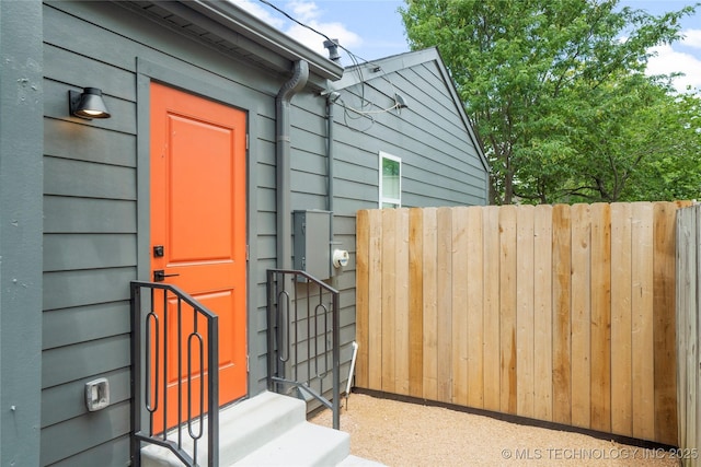 doorway to property featuring fence
