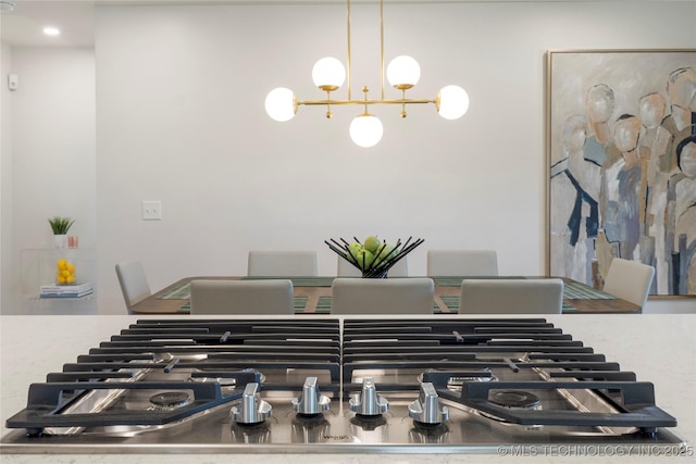 details featuring stainless steel gas cooktop and a chandelier