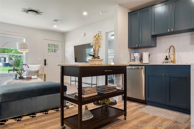 bar with a sink, light wood-style floors, backsplash, recessed lighting, and stainless steel dishwasher