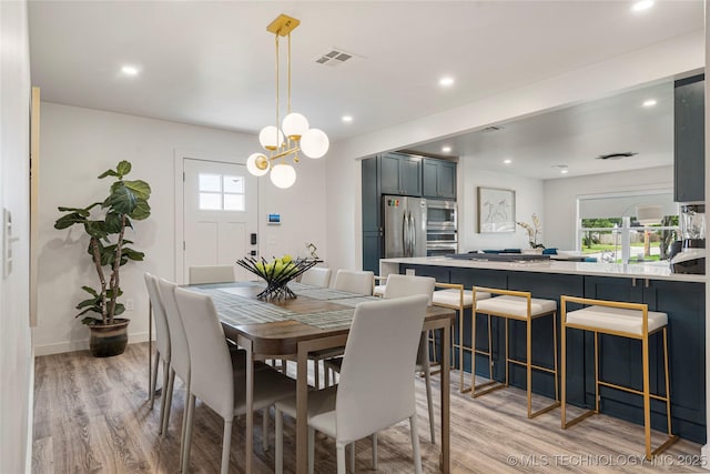 dining space with recessed lighting, a healthy amount of sunlight, and light wood finished floors