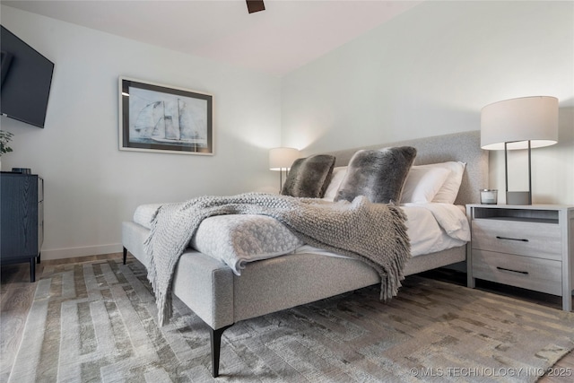 bedroom with baseboards and wood finished floors