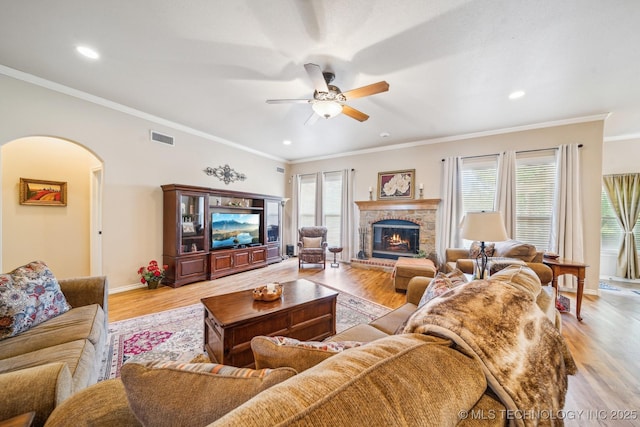 living room featuring ceiling fan, arched walkways, light wood-style flooring, recessed lighting, and visible vents