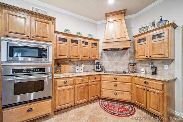 kitchen with ornamental molding, custom exhaust hood, light stone countertops, backsplash, and stainless steel appliances