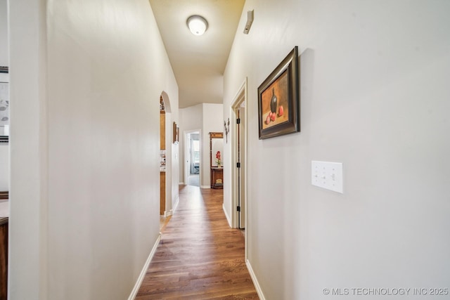 hallway featuring baseboards and wood finished floors