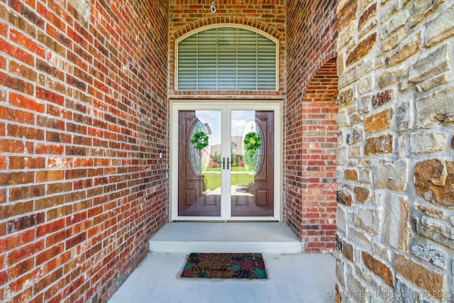 entrance to property featuring french doors and brick siding