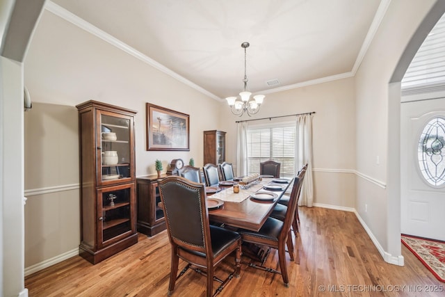 dining space with visible vents, a chandelier, a healthy amount of sunlight, and light wood-type flooring