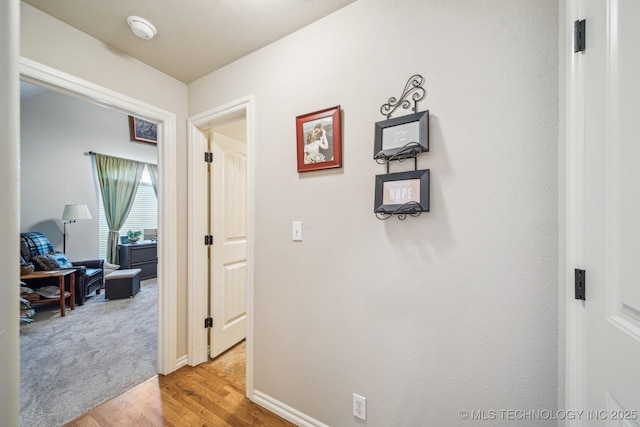 hall featuring baseboards and light wood-type flooring
