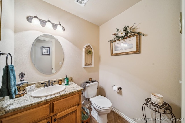 half bath with visible vents, tile patterned flooring, vanity, baseboards, and toilet