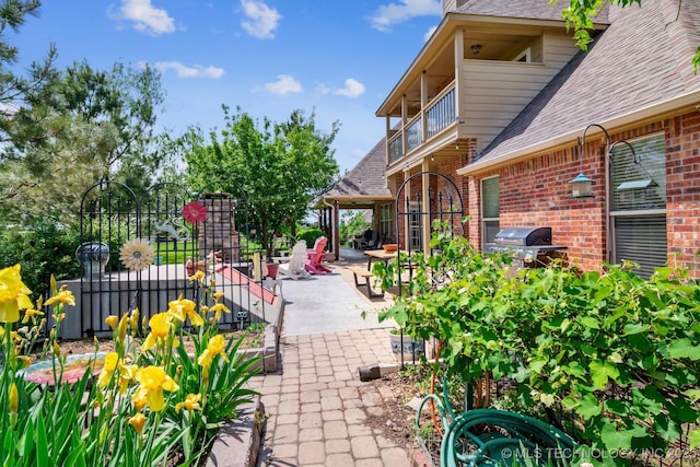 view of patio with fence, a balcony, and area for grilling