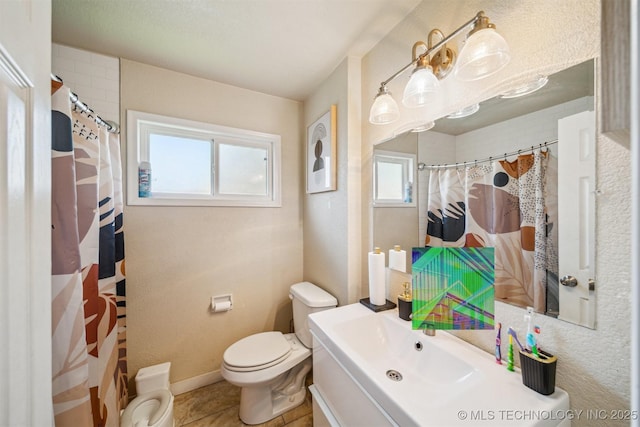 bathroom with a shower with curtain, vanity, tile patterned floors, baseboards, and toilet