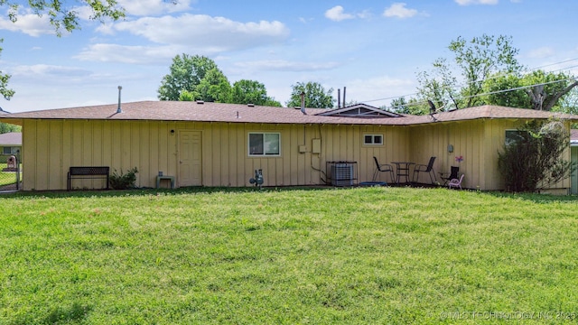 rear view of property with a lawn, fence, board and batten siding, and cooling unit