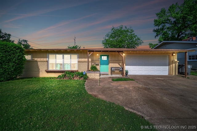 ranch-style home with brick siding, a front lawn, an attached garage, and concrete driveway