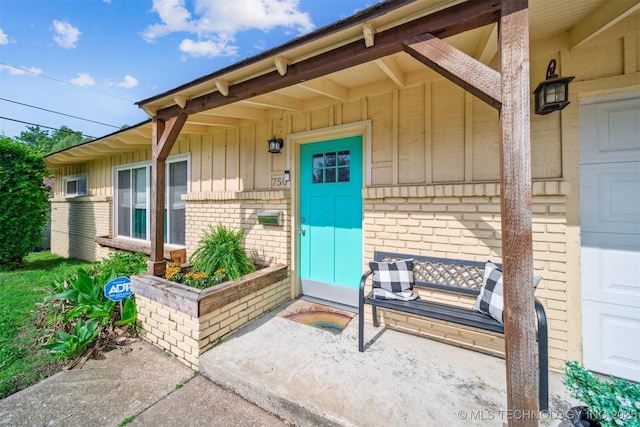 entrance to property featuring board and batten siding and brick siding