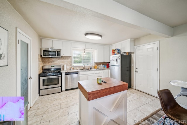 kitchen featuring a sink, tasteful backsplash, white cabinets, and stainless steel appliances
