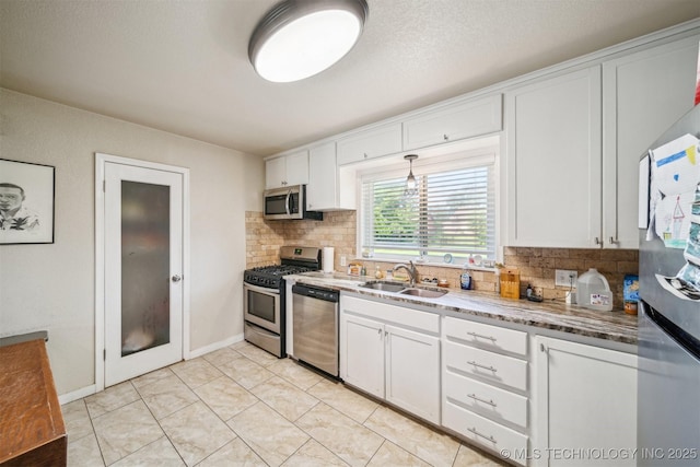 kitchen featuring a sink, white cabinets, backsplash, and stainless steel appliances