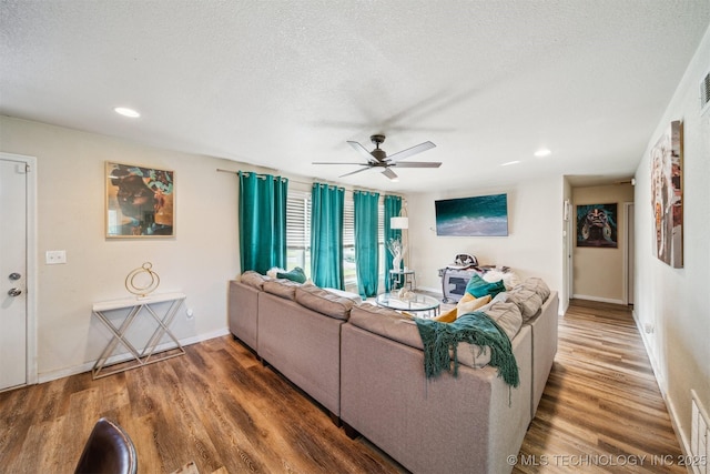 living area with a textured ceiling, a ceiling fan, recessed lighting, and wood finished floors