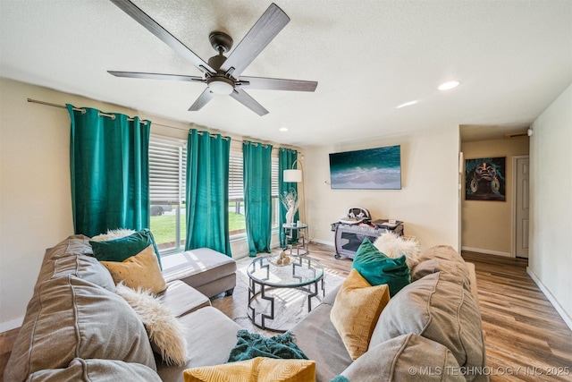 living room featuring baseboards, a ceiling fan, recessed lighting, and wood finished floors