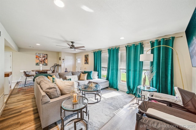 living room with baseboards, recessed lighting, ceiling fan, and wood finished floors