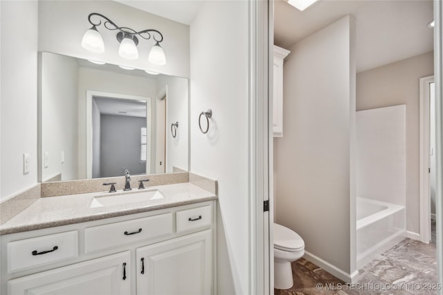 bathroom featuring vanity, baseboards, and toilet