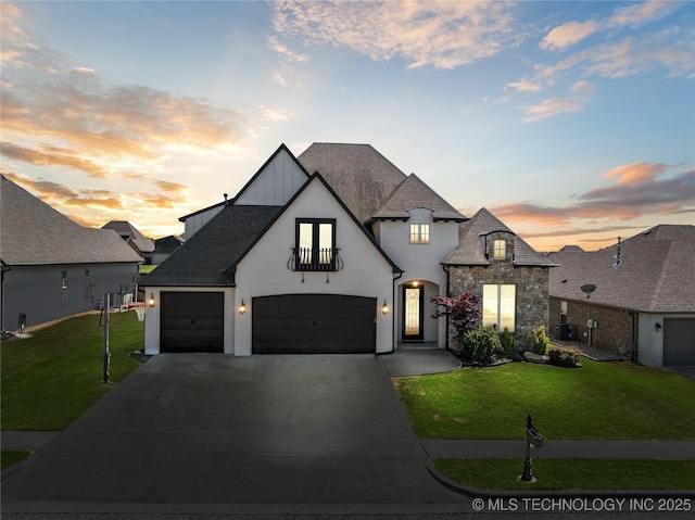 french provincial home with an attached garage, stone siding, concrete driveway, and a front yard