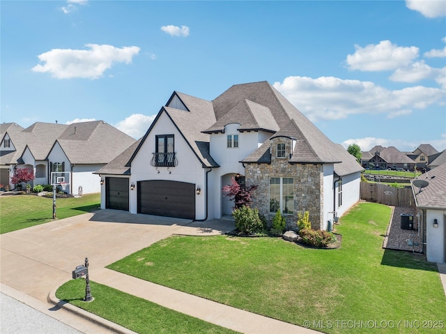 french country style house with fence, a front yard, driveway, and stone siding
