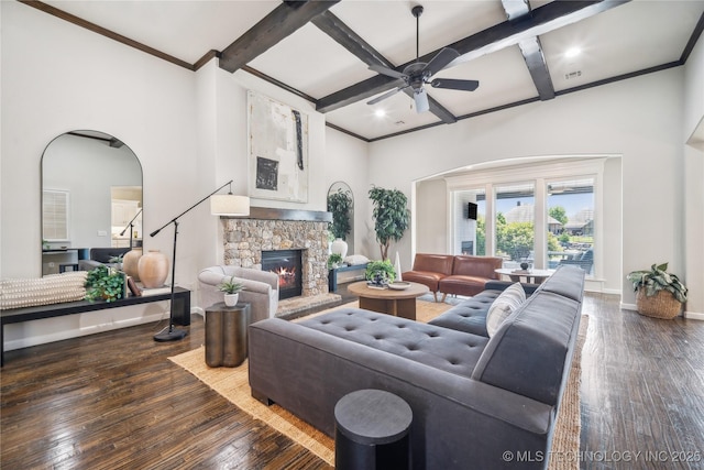living area with wood-type flooring, a stone fireplace, a ceiling fan, baseboards, and coffered ceiling