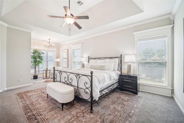 carpeted bedroom with ceiling fan with notable chandelier, baseboards, a tray ceiling, visible vents, and ornamental molding